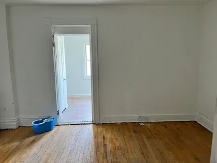 a view of empty room with wooden floor