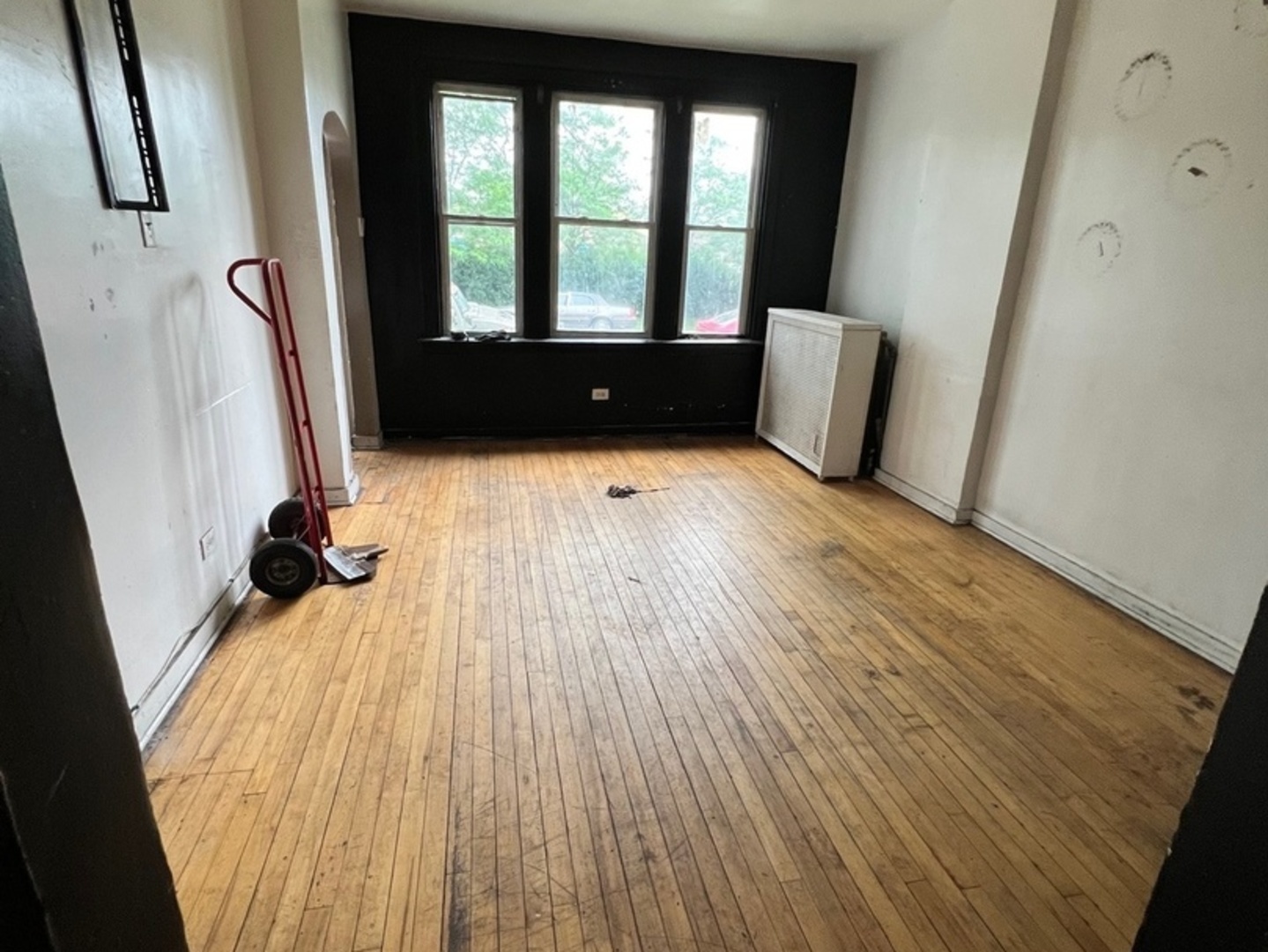 10614 South Langley Avenue, Unit 10614 Chicago, IL 60628 - Photo 7 of 11 a view of an empty room with a window and wooden floor