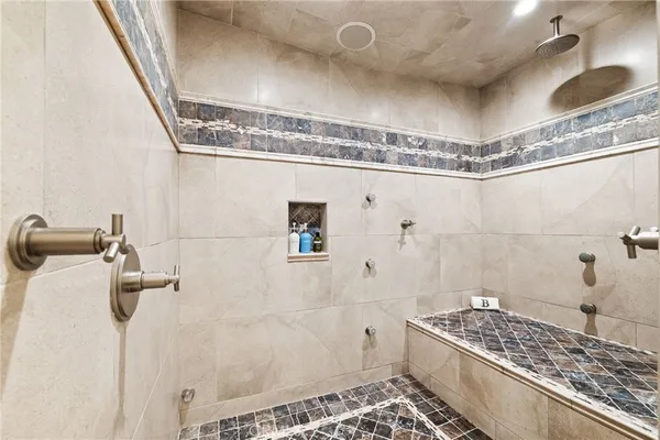a large white kitchen with a large window and stainless steel appliances
