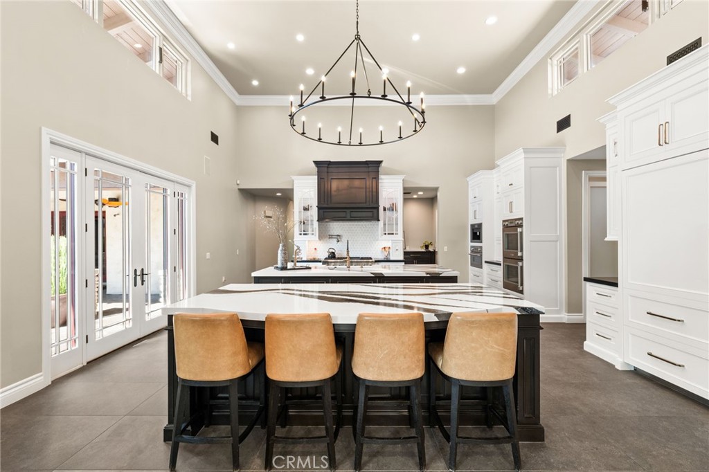 1688 Dwight Street Redlands, CA 92373 - Photo 27 of 72 a large kitchen with a dining table chairs wooden floor and cabinets