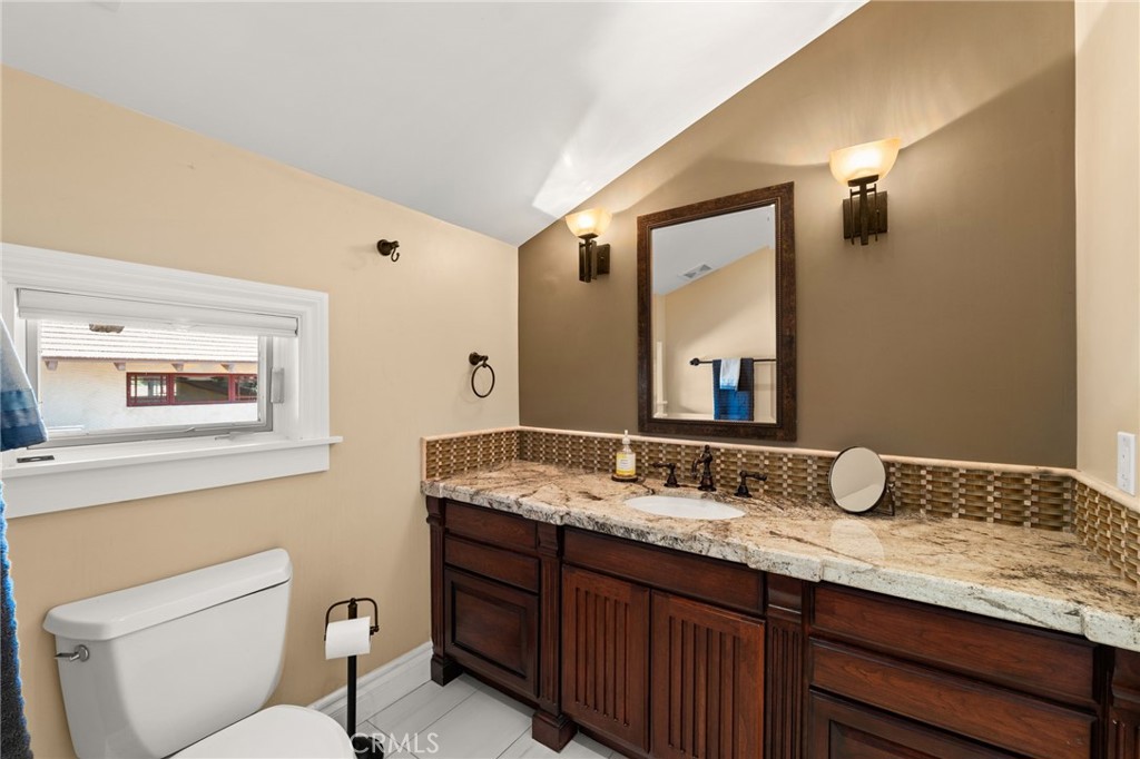 1688 Dwight Street Redlands, CA 92373 - Photo 45 of 72 a bathroom with a granite countertop sink mirror vanity and toilet
