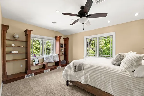 a front view of a house with a yard and potted plants