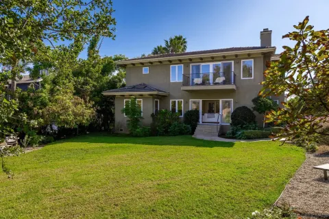 a view of a house with a yard and potted plants