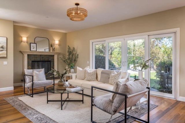 a living room with furniture a fireplace and a large window