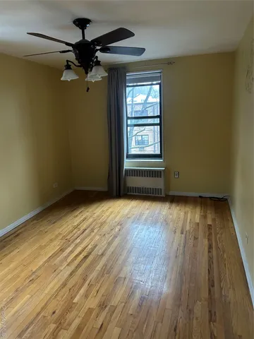 a view of a room with wooden floor and a window