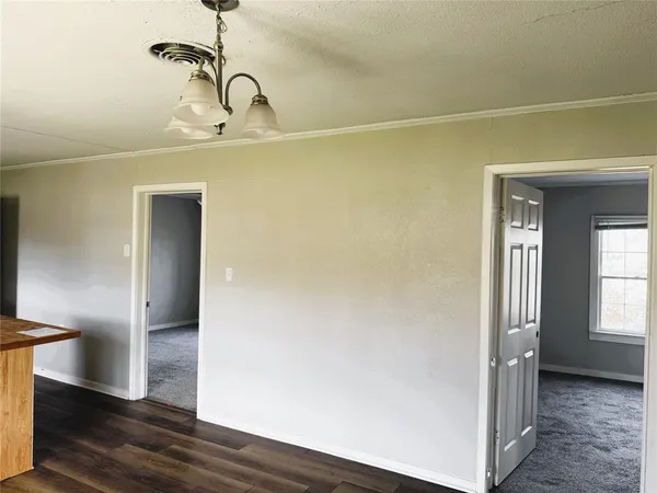a view of a room with wooden floor and a white door
