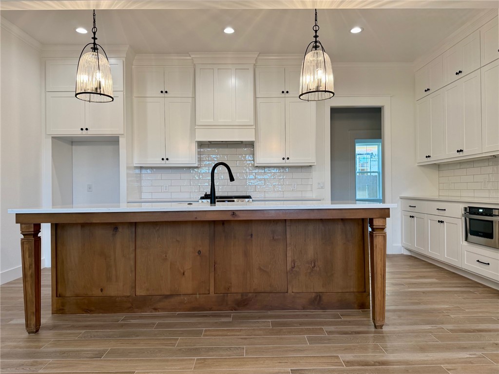 4015 Pacific Crest Way Bryan, TX 77802 - Photo 4 of 22 a kitchen with kitchen island granite countertop a sink cabinets and wooden floor