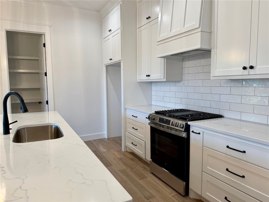 4015 Pacific Crest Way Bryan, TX 77802 - Photo 5 of 22 a kitchen with granite countertop white cabinets and stainless steel appliances
