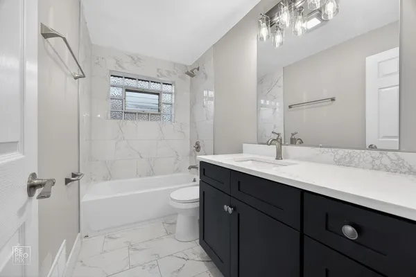 a bathroom with a tub a sink and mirror