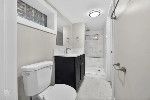 a bathroom with a sink a toilet and shower