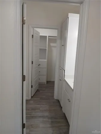 a view of a hallway with wooden floor