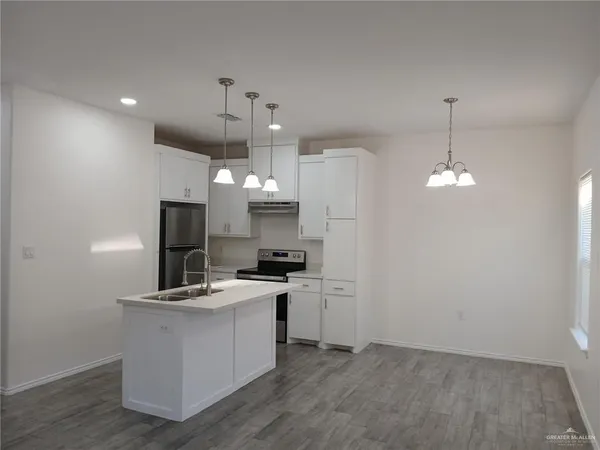 a kitchen that has a lot of cabinets and refrigerator in it