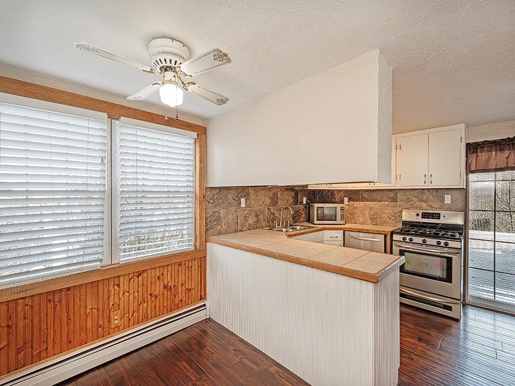 223-227 Old Mill Road Apollo, PA 15613 - Photo 17 of 45 a kitchen with stainless steel appliances granite countertop a stove a sink and dishwasher with wooden floor