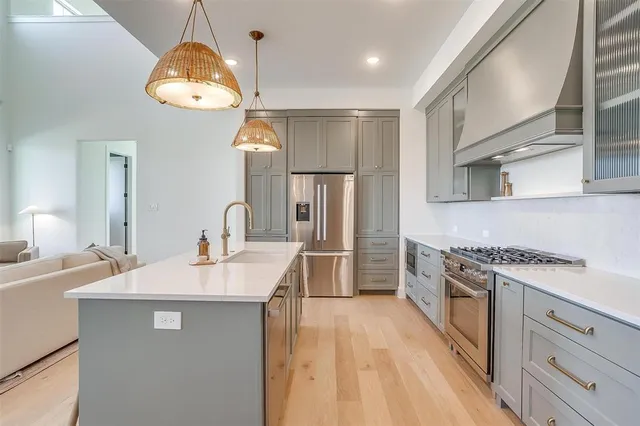 a kitchen with stainless steel appliances granite countertop a sink a stove refrigerator and cabinets