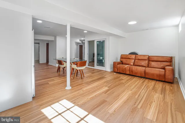 a living room with furniture a wooden floor and next to a window
