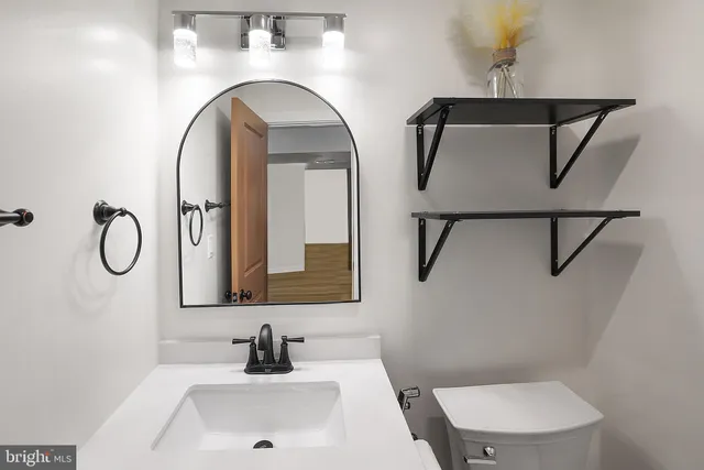 a bathroom with a toilet sink and mirror