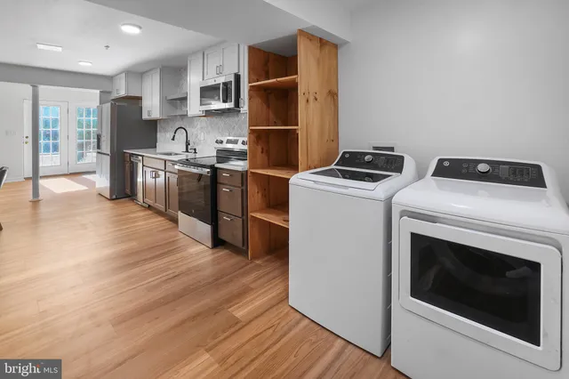a kitchen with stainless steel appliances a stove a microwave and a hard wood floor