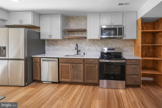 a kitchen with a sink a microwave a refrigerator and cabinets