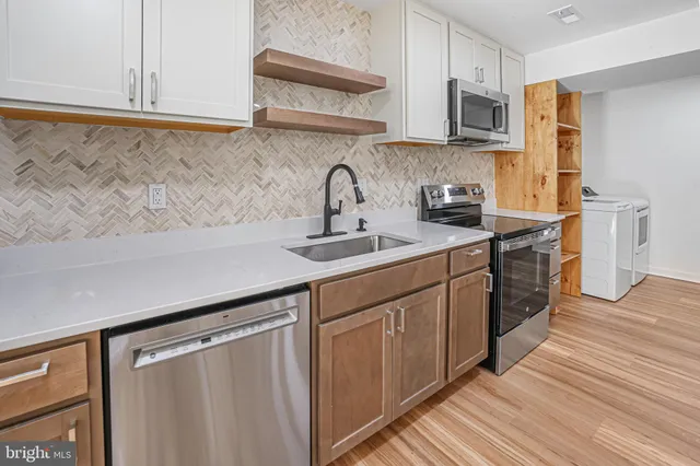 a kitchen with stainless steel appliances granite countertop a sink and a stove top oven