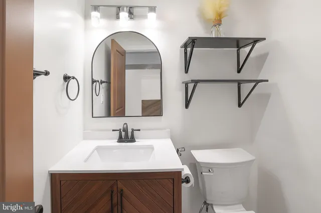 a bathroom with a sink a toilet and mirror