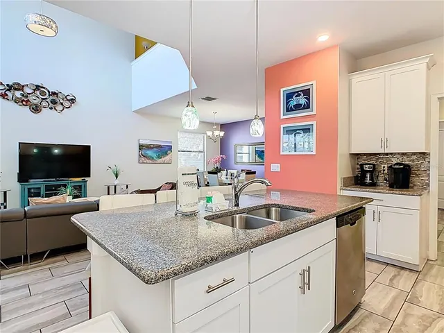 a kitchen with granite countertop a sink and a stove top oven