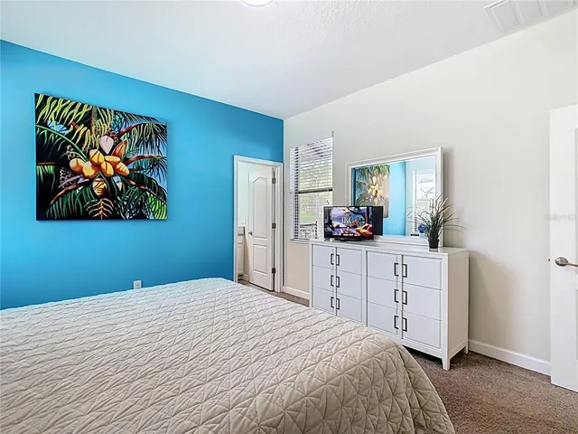 a bedroom with a large bed and a mirror