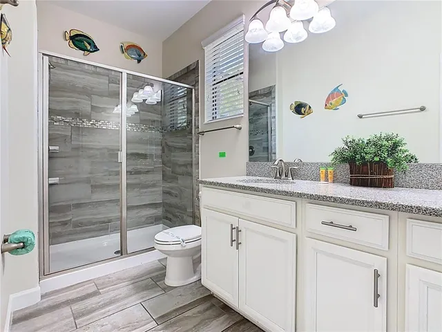 a bathroom with a granite countertop sink a toilet and a mirror