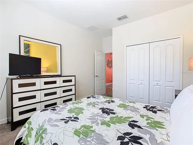 a bedroom with a bed and a flat screen tv