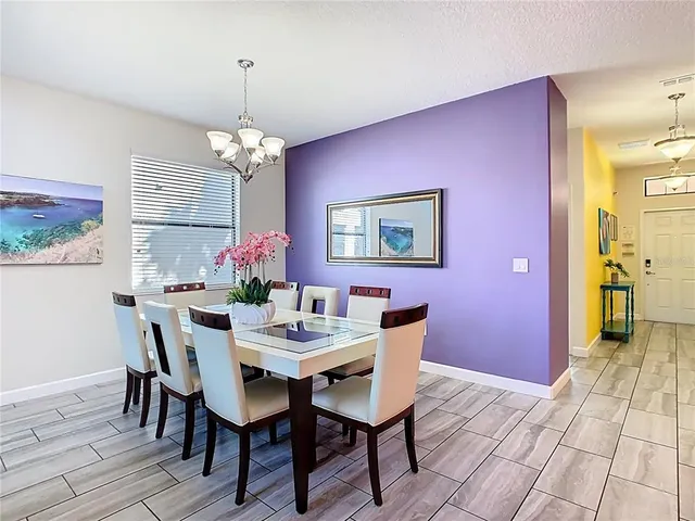 a dining room with furniture a chandelier and wooden floor