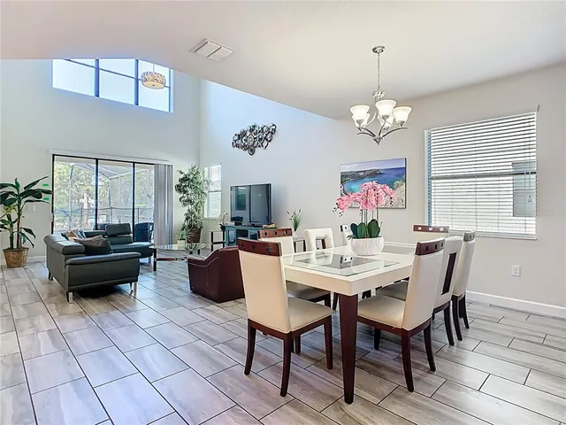 a view of a dining room with furniture a chandelier and wooden floor
