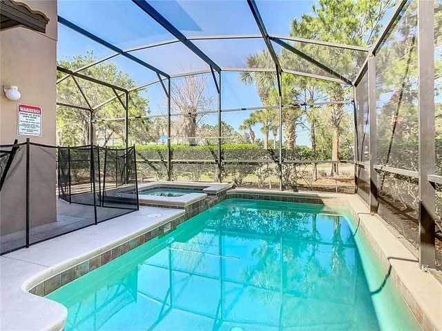 a view of a swimming pool with a patio and a yard