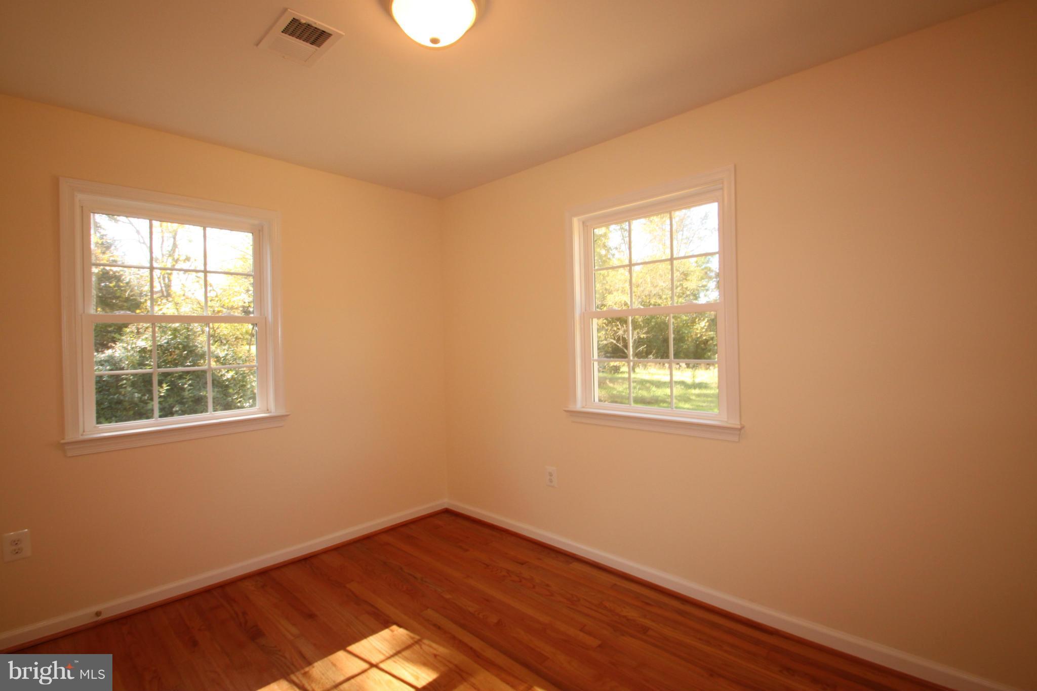 14394 Shanktown Road Reva, VA 22735 - Photo 14 of 18 a view of an empty room with wooden floor and a window