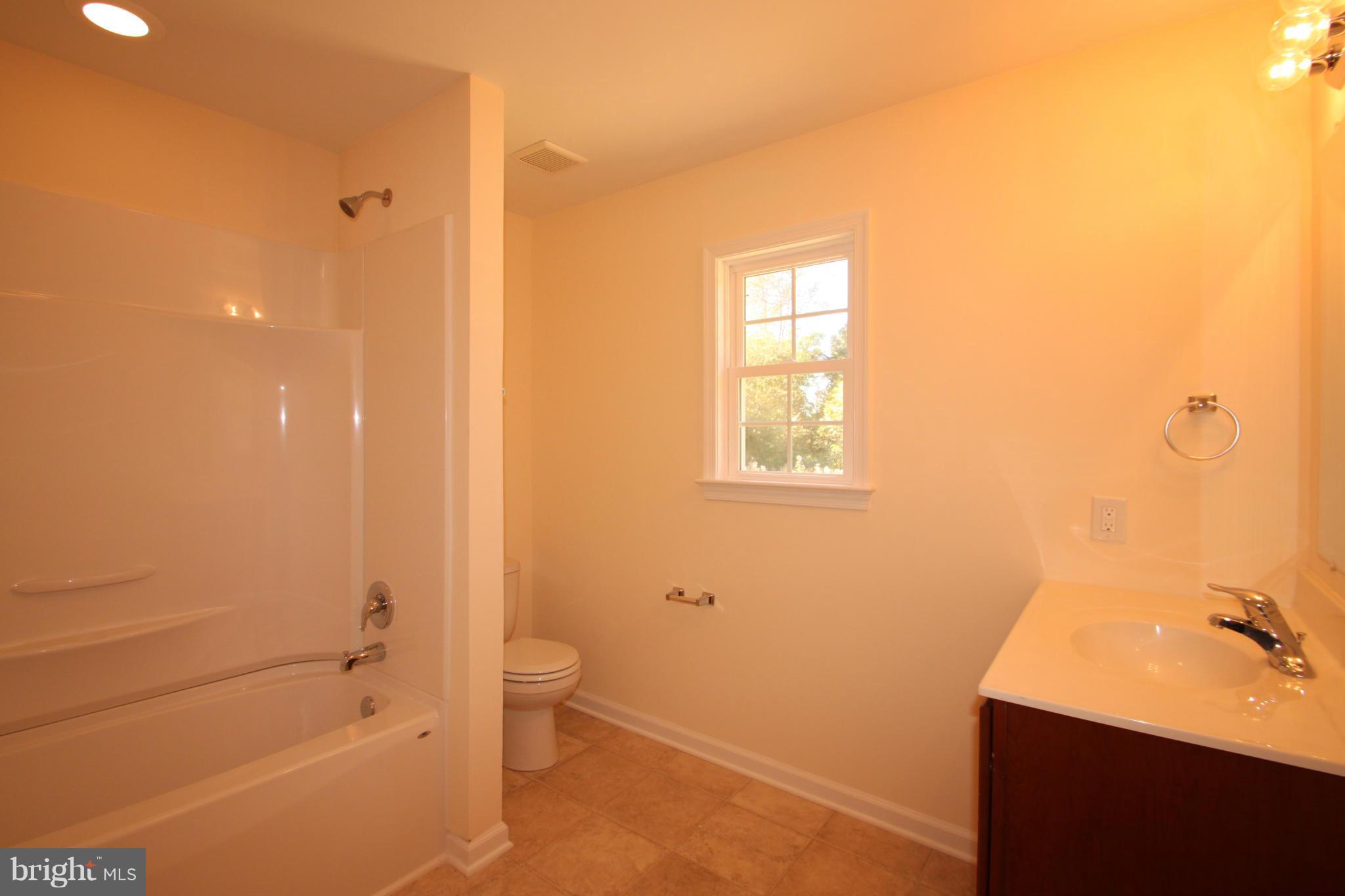 14394 Shanktown Road Reva, VA 22735 - Photo 4 of 18 a bathroom with a granite countertop sink a toilet and shower
