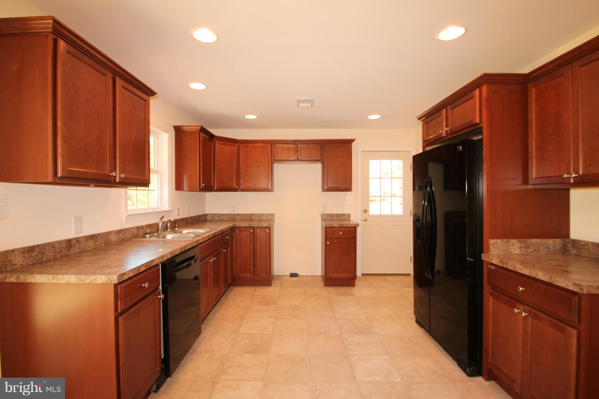 14394 Shanktown Road Reva, VA 22735 - Photo 7 of 18 a kitchen with stainless steel appliances granite countertop a refrigerator a sink and wooden cabinets