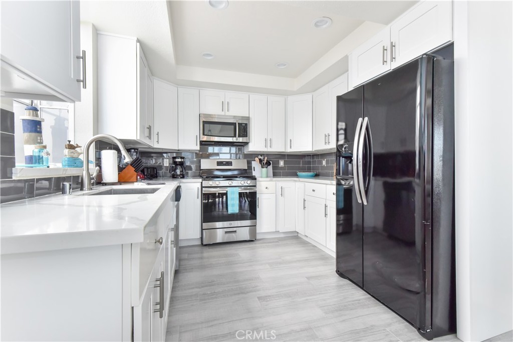 16791 Bayview Drive Huntington Beach, CA 90742 - Photo 12 of 75 a kitchen with stainless steel appliances a refrigerator sink and microwave