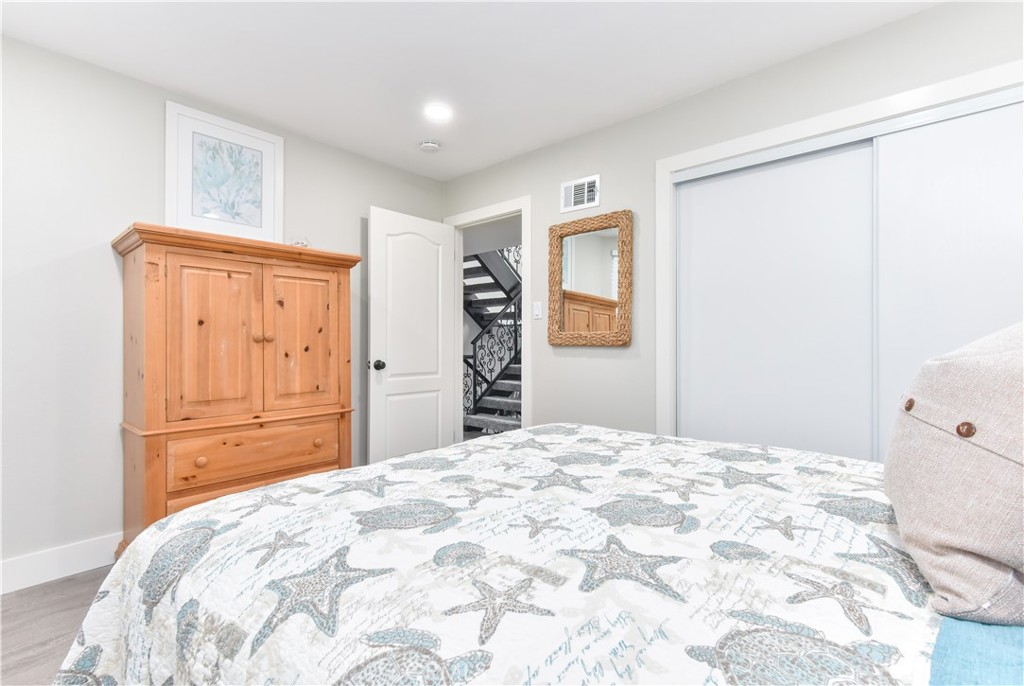 16791 Bayview Drive Huntington Beach, CA 90742 - Photo 47 of 75 a bedroom with a large bed and wooden floor