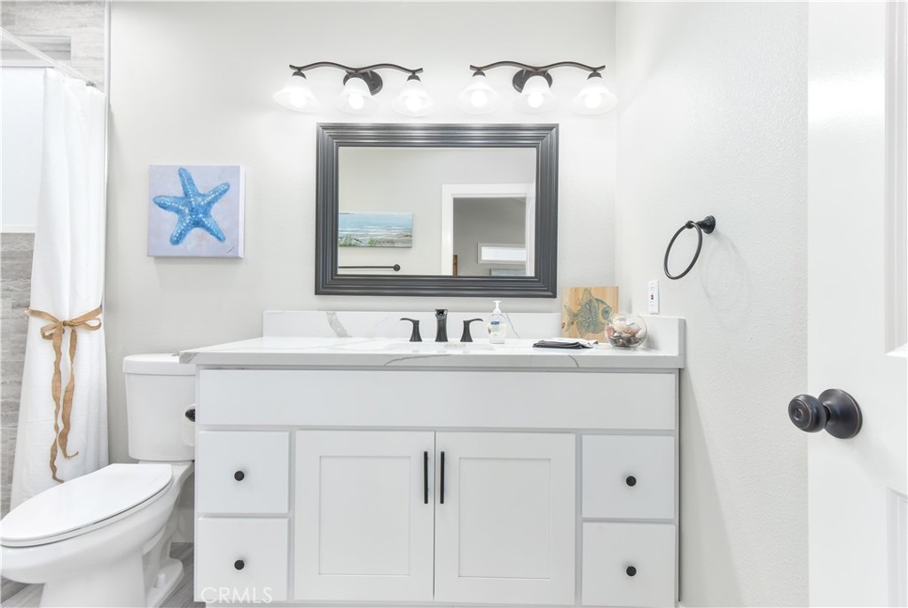 16791 Bayview Drive Huntington Beach, CA 90742 - Photo 56 of 75 a bathroom with a toilet sink and mirror
