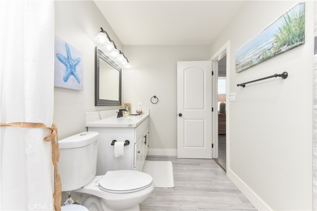 16791 Bayview Drive Huntington Beach, CA 90742 - Photo 60 of 75 a bathroom with a sink a toilet a mirror and shower