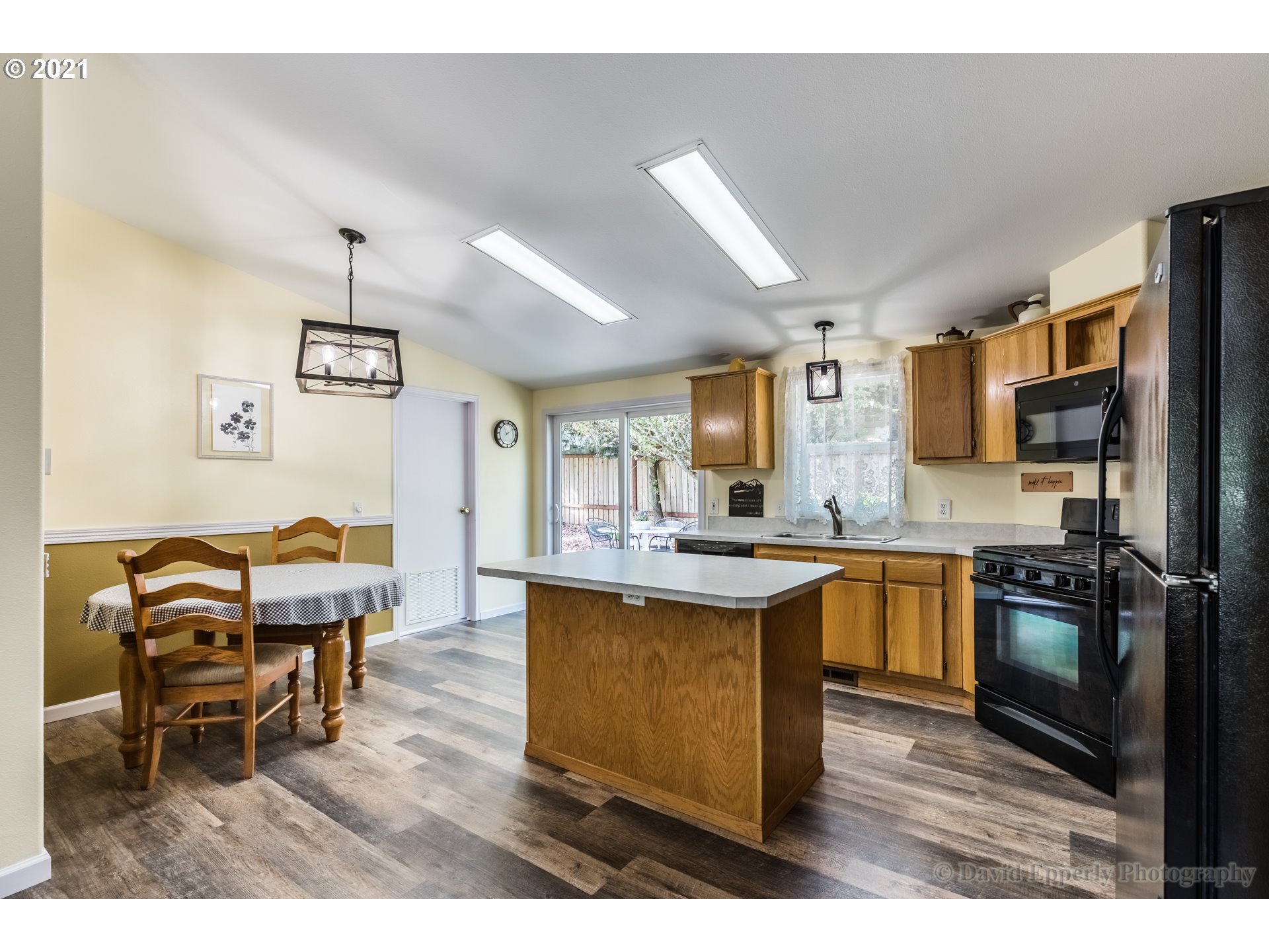 75040 Lewis Road Rainier, OR 97048 - Photo 8 of 22 a kitchen with stainless steel appliances granite countertop a stove top oven a sink dishwasher a dining table and chairs with wooden floor