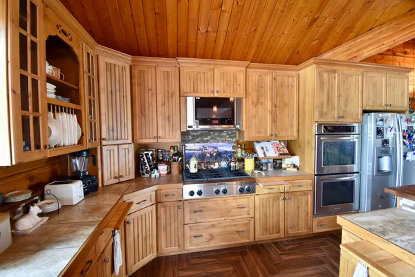 a kitchen with stainless steel appliances a stove top oven a sink and cabinets