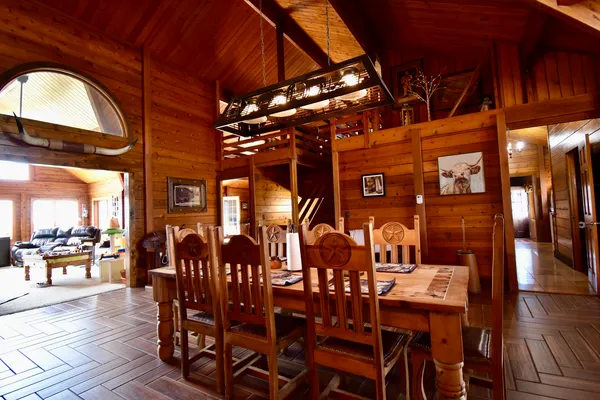 a dining room with furniture a chandelier and wooden floor
