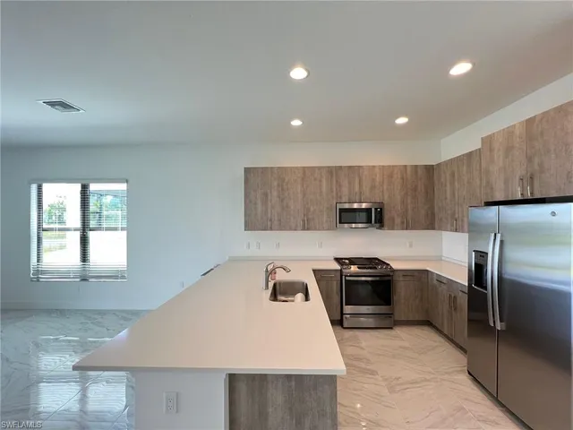 a kitchen with kitchen island a sink stove and refrigerator