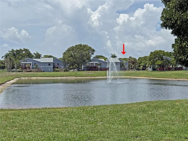 a view of a house with a big yard and a large trees