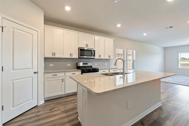 a kitchen with appliances a sink and cabinets