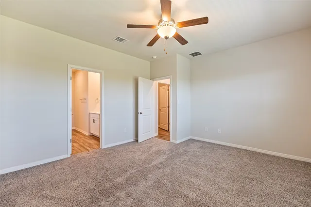 an empty room with closet and a ceiling fan