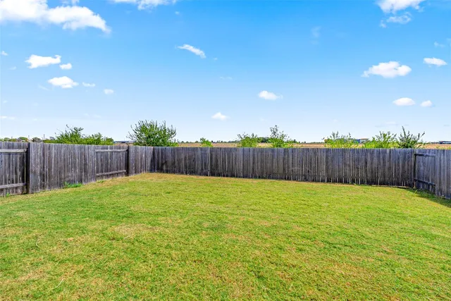 a view of a backyard with wooden fence