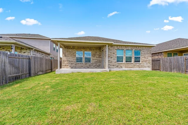 a view of a house with a backyard and a patio