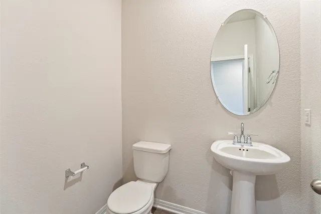 a bathroom with a toilet a sink and mirror