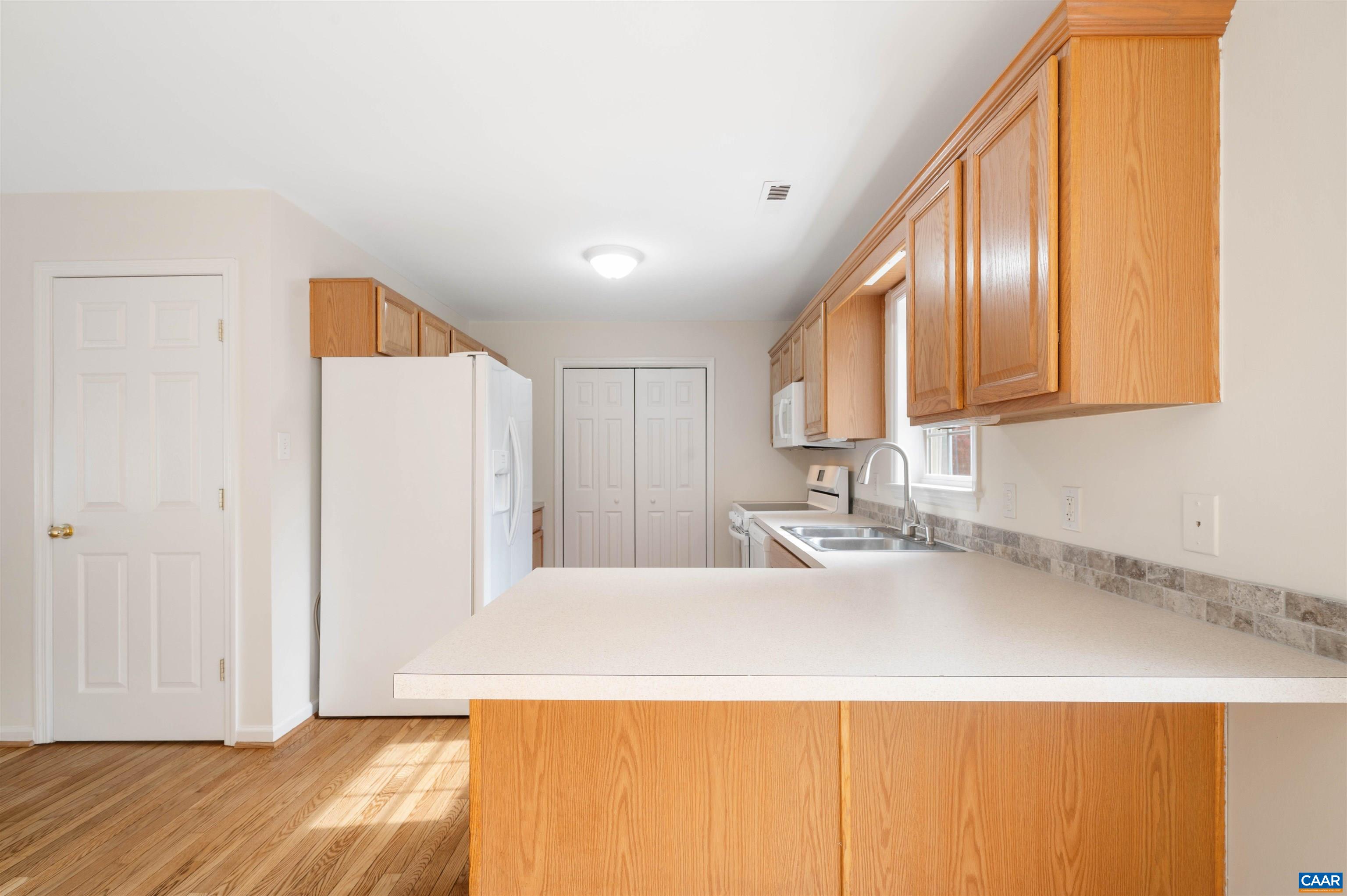 328 West Daffodil Road Ruckersville, VA 22968 - Photo 11 of 67 a kitchen with a sink a refrigerator and wooden cabinets