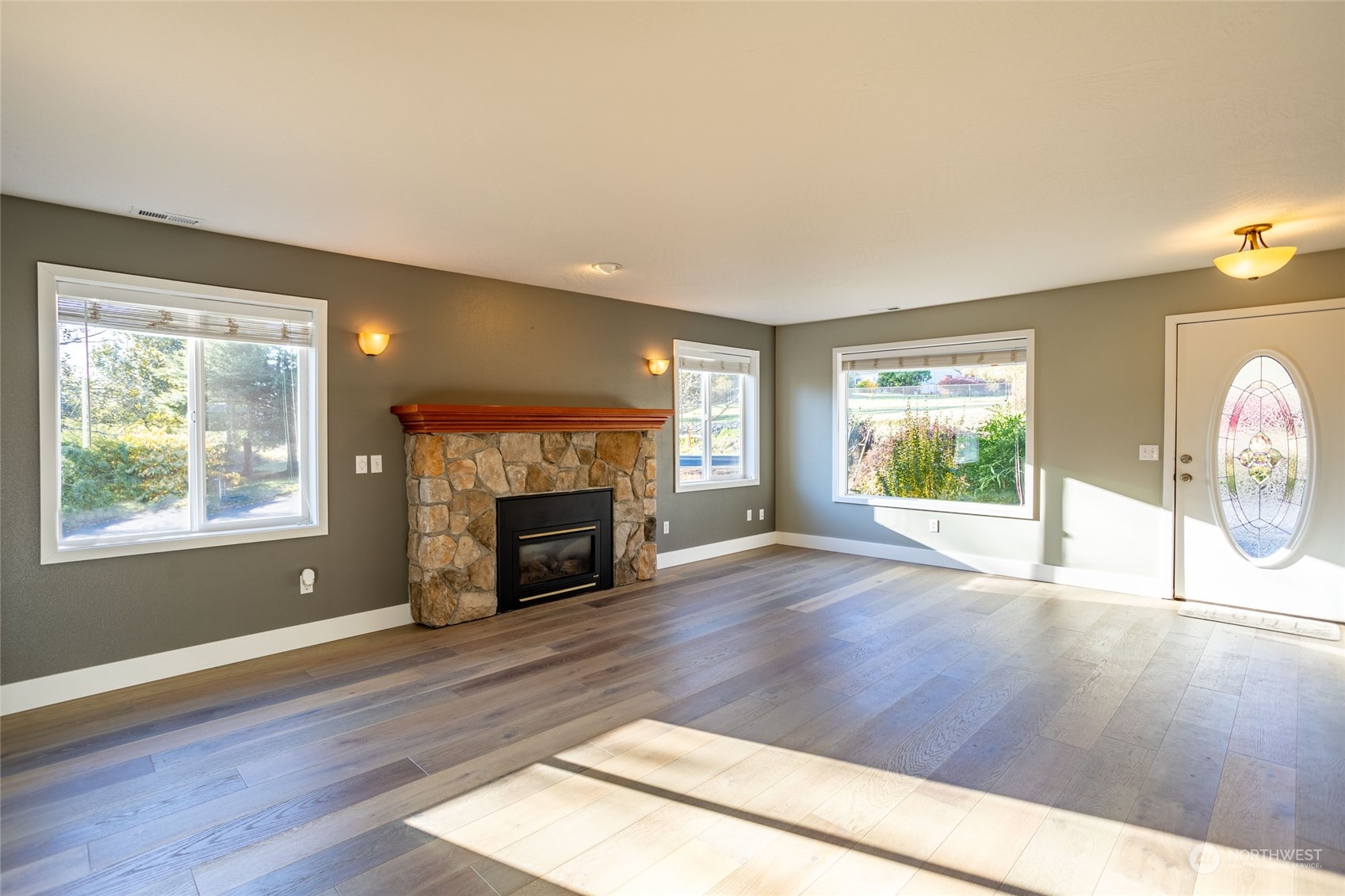 150 Logan Hill Road Chehalis, WA 98532 - Photo 3 of 40 an empty room with windows a fireplace and wooden floor